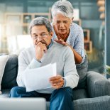 Article thumbnail: Shot of a mature couple looking worried while going through paperwork together at home